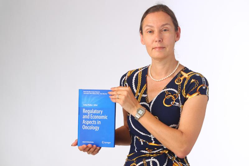 Frau Dr. Evelyn Walter hält das Buch "Regulatory and Economic Aspects in Oncology"